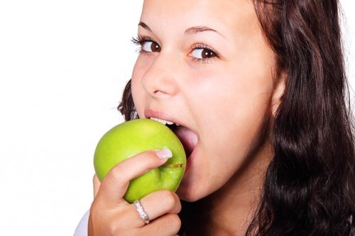 Kobieta gryzie zielone jabłko