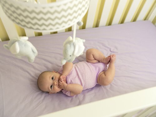 Noworodek patrzy na karuzelę nad łóżeczkiem