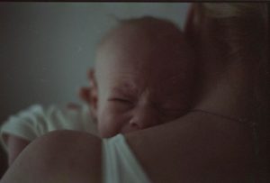 Płaczące dziecko w ramionach matki