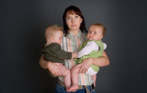 Wyczerpanie - zmęczona matka trzyma dwoje dzieci