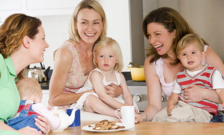 Radosne kobiety z dziećmi przy stole