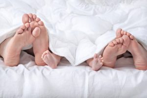 Śpiąca rodzina - stopy wystające spod kołdry 