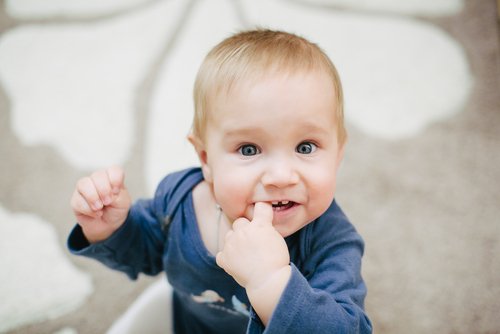 Dziecko wkładające palec do ust i gryzące go