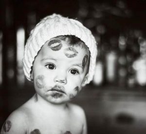 Smutne dziecko ze śladami pocałunków