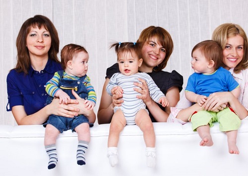 Mamy trzydziestolatki trzymające dzieci na rękach