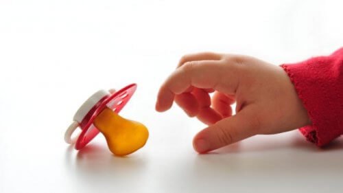 Rączka dziecka sięgająca po smoczek