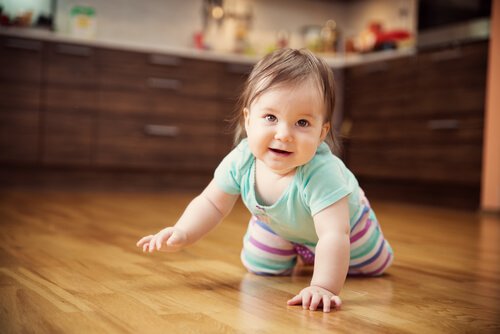 Raczkująca dziewczynka na podłodze - siódmy miesiąc życia dziecka