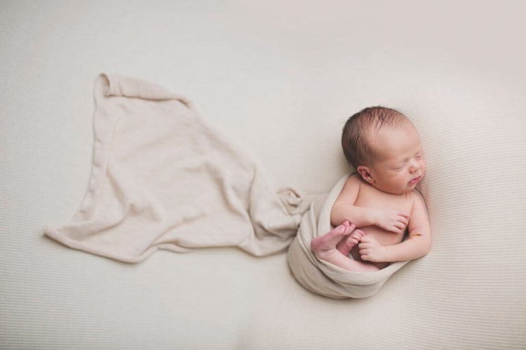 Śpiące dziecko owinięte kocykiem