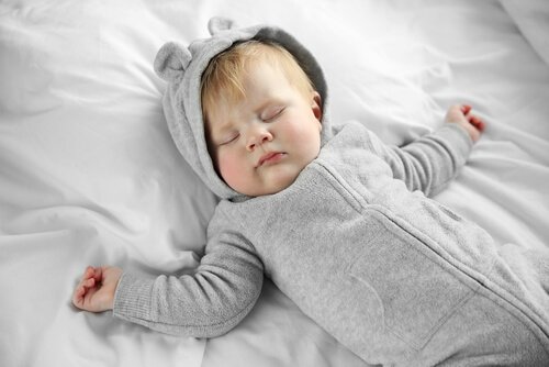 Śpiące niemowlę w piżamce z kapturem z uszkami