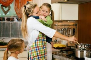 Zapracowana kobieta w kuchni z dziećmi