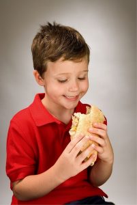 Zdrowie drugie śniadanie - chłopiec je kanapkę