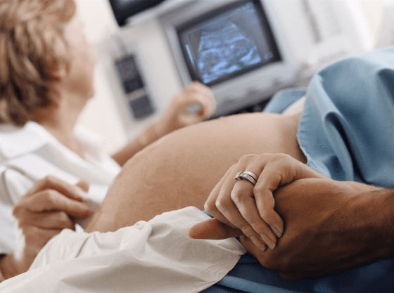 Brzuch mamy w ciąży w trakcie USG - myśli nachodzące mamę w trakcie ciąży