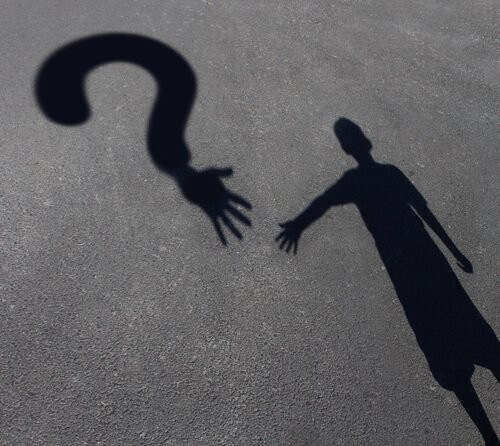 Cień chłopczyka, który chce sięgnąć ręką znak zapytania