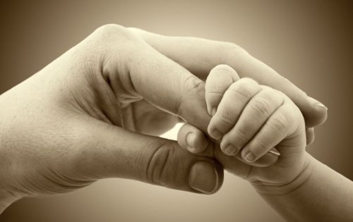 Dłoń matki i dziecka w uścisku