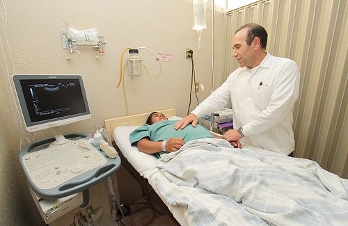 Lekarz bada kobietę, by wykluczyć ewentualne powikłania ciążowe