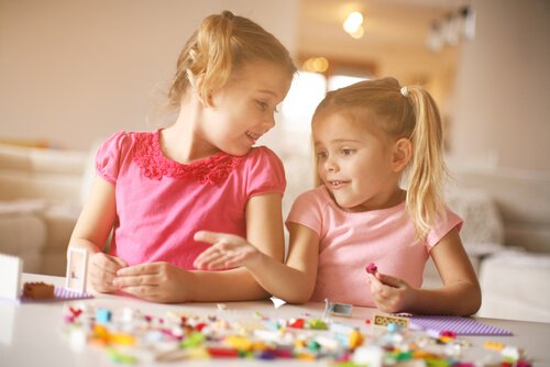 Dwie dziewczynki układające klocki LEGO na stole