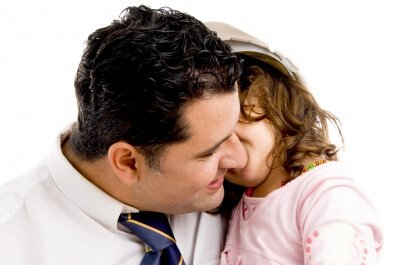 Dziewczynka szepcząca do ucha taty - zasada bielizny, której warto nauczyć dziecko