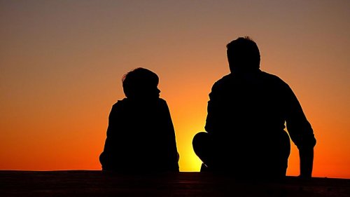 wychować syna na prawdziwego dżentelmena - ojciec i syn rozmawiają o zachodzie słońca