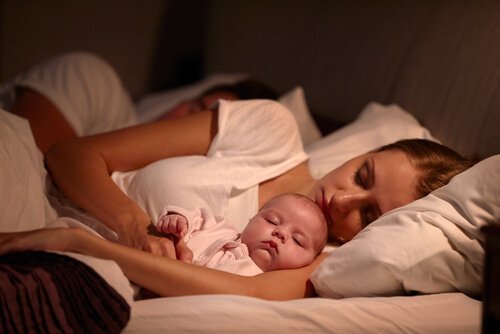 Spanie w łóżeczku - mama i dziecko śpią