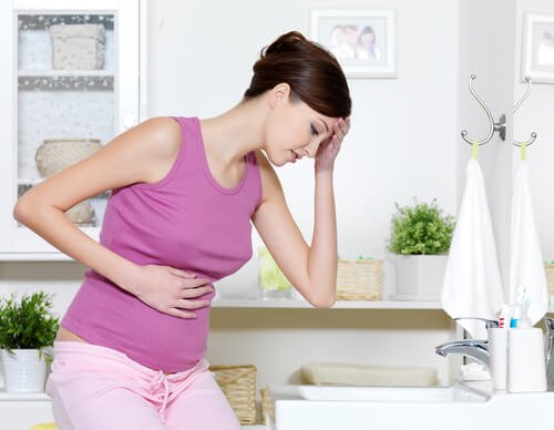 Kobieta w ciąży trzymająca się za brzuch