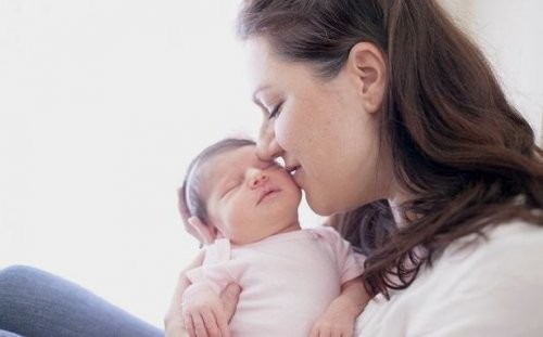 Świeżo upieczona mama całująca noworodka