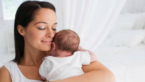 Kobieta została matką, tuli swoje dziecko