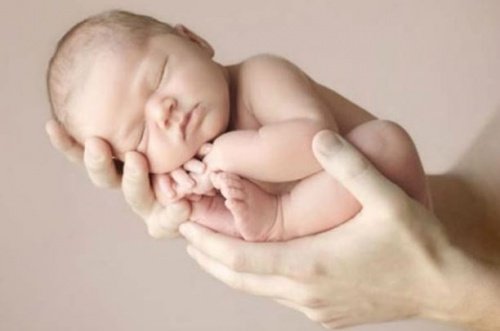 Niemowlę trzymane na rękach - dzień narodzin dziecka