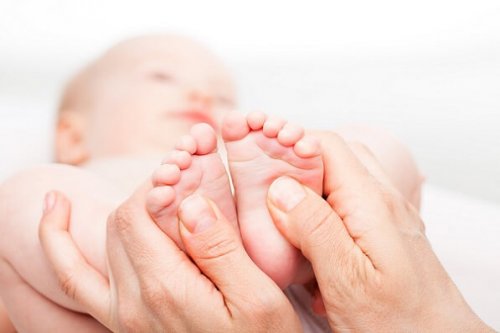 Ręce masujące stopy niemowlęcia