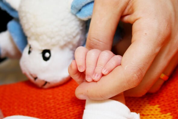 Ręka kobiety trzymająca rączkę dziecka