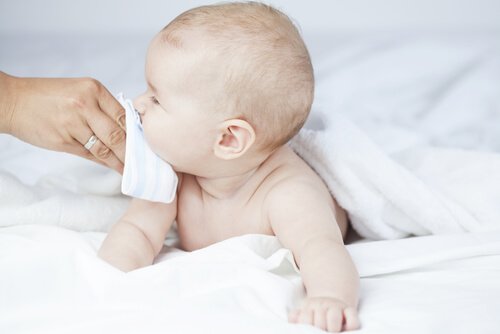 Ręka wycierająca nos niemowlakowi