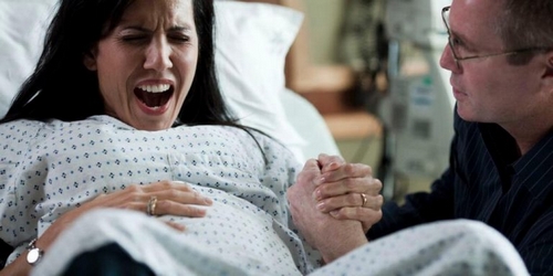 Rodząca kobieta odczuwa ból podczas porodu
