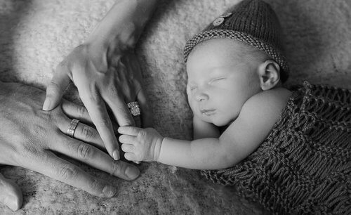 Dziecko i ręce rodziców chrzestnych