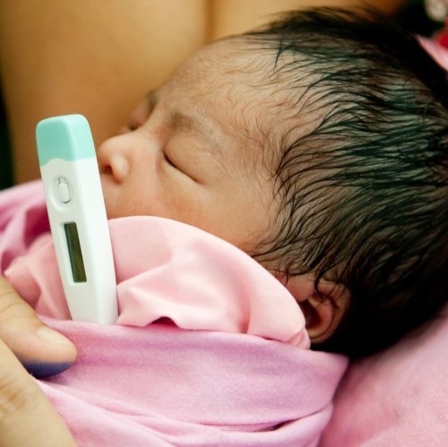 Dziecko z objawami odwodnienia z termometrem pod pachą