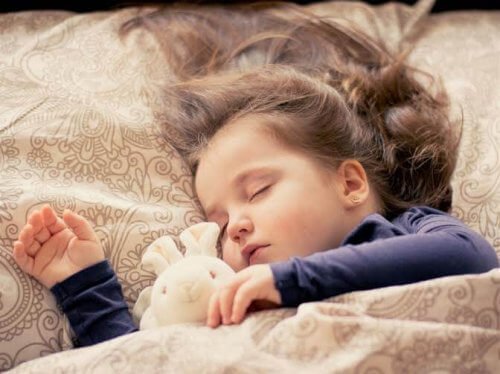 Dziewczynka śpiąca z pluszowym króliczkiem
