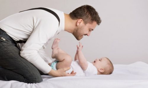 Jak łaskotać i całować dziecko po brzuchu - tata bawi się z niemowlęciem
