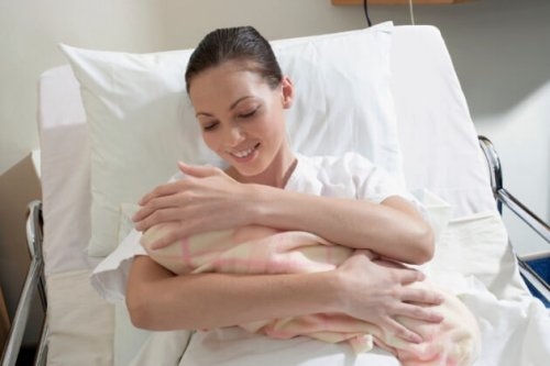 Kobieta trzymająca nowonarodzone dziecko po porodzie