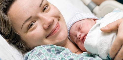 Uśmiechnięta mama po porodzie