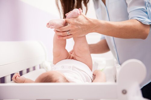 Mama zmieniająca pieluszkę dziecku na przewijaku
