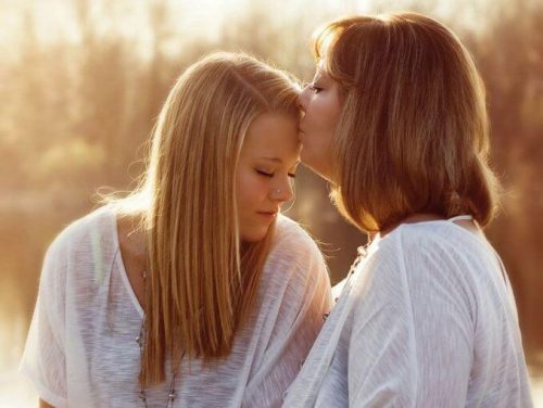 Matka całuje córkę w czoło