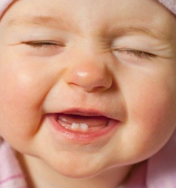 Śmiejące się niemowlę z dwoma ząbkami