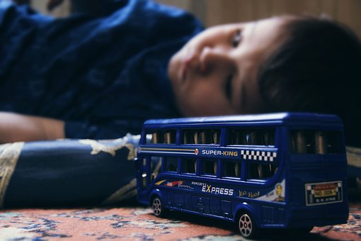 Zabawka autobus w tle chłopiec leżący na podłodze