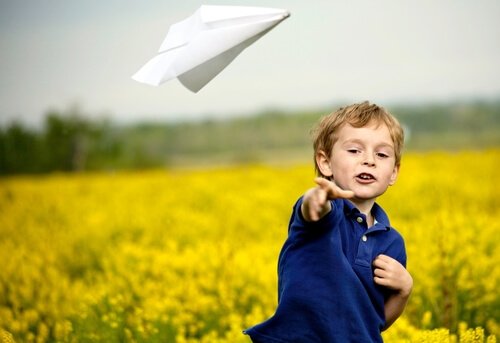 Chłopiec puszcza papierowy samolocik