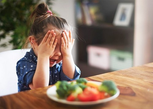 Dziewczynka płacząca nad warzywami
