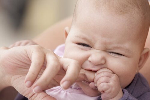 Dziecko gryzące palec dorosłego