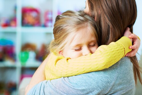Mama przytulająca smutną dziewczynkę