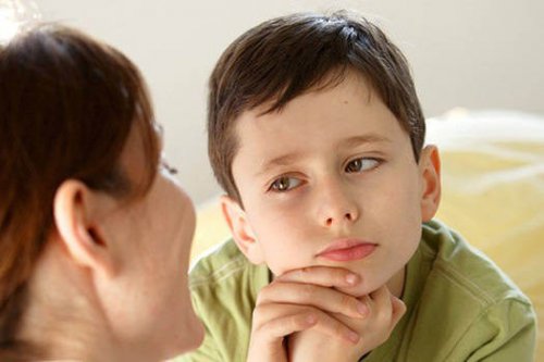 Mama rozmawiająca z chłopcem podpierającym głowę na rękach - jak powinno wyglądać odmawianie dziecku