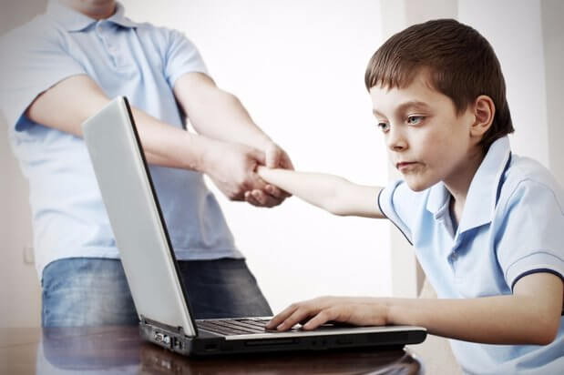 Tata odciągający syna od laptopa - zasada 3-6-9-12 uczy odpowiedzialnego korzystania ze zdobyczy technologii