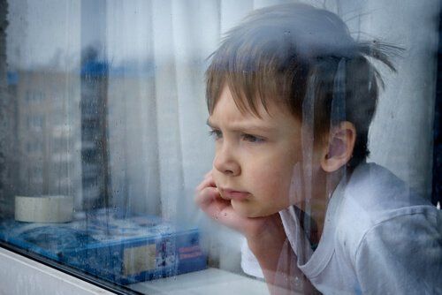 Chłopiec zamyślony patrzy przez okno