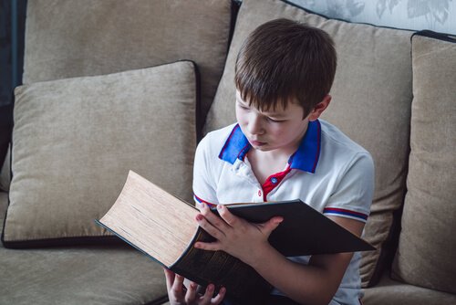 Hiszpańskie imiona chłopięce - chłopiec czyta grubą księgę