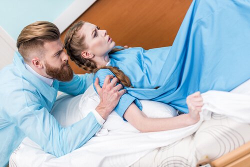 Kobieta rodzi wspierana przez męża